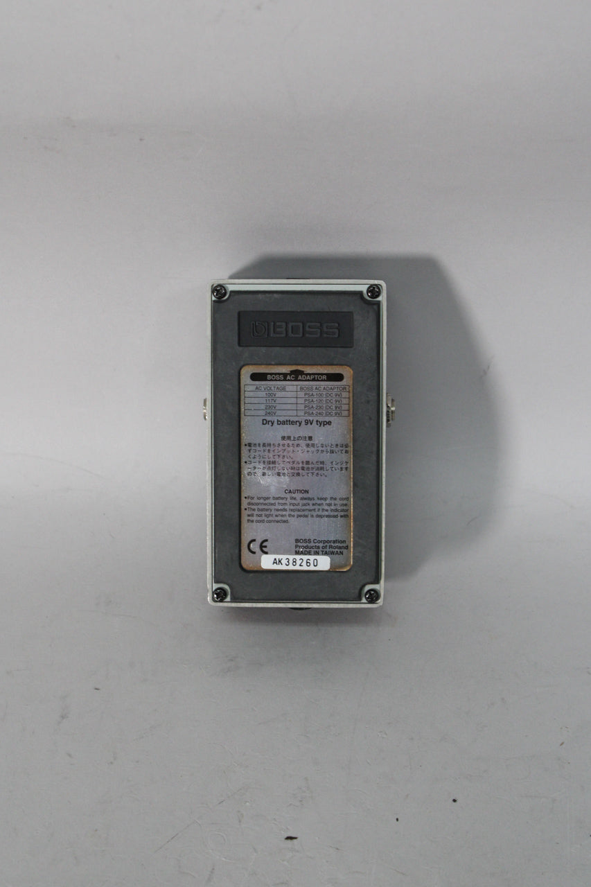 The pedal's grey base plate is visible, with a large black sticker covering most of it, showing text and a serial number.
