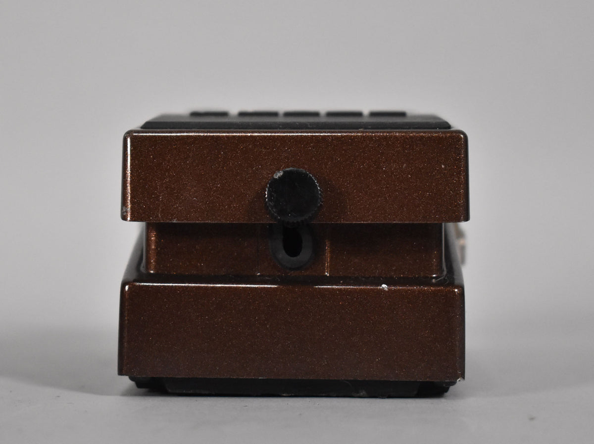The brown metallic effect pedal is viewed from the right side, showing a black input jack and a small chip on the top edge.