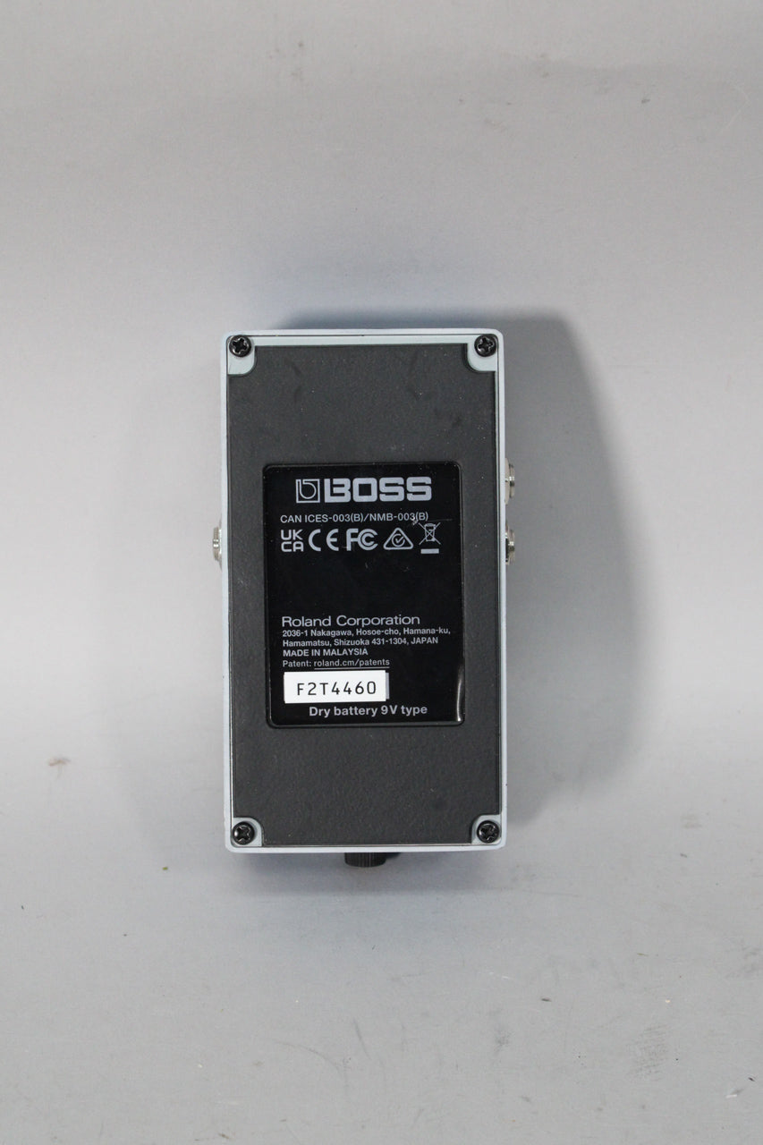 The pedal's gray underside is visible, featuring a black rectangular label with white text and a serial number.