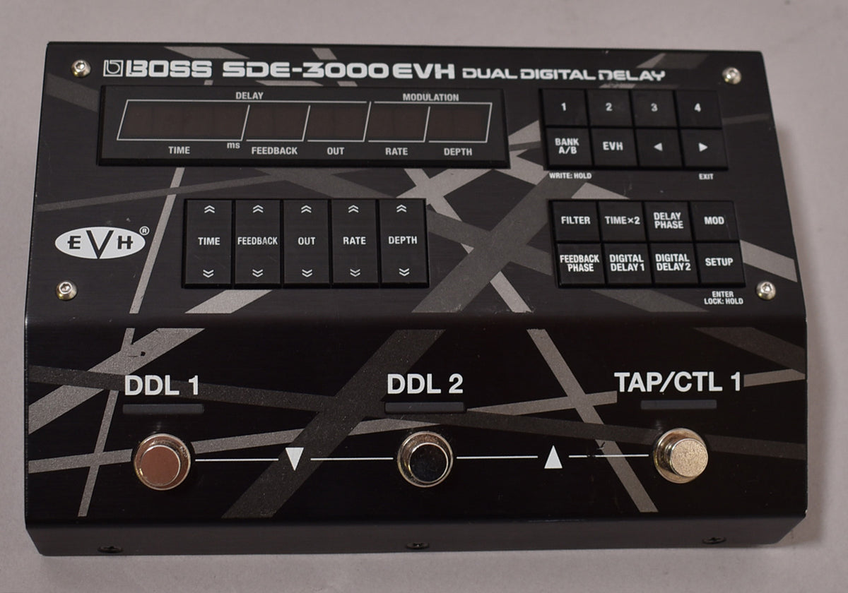 A black digital delay pedal with a gray striped pattern, three footswitches, and multiple black buttons and screens.