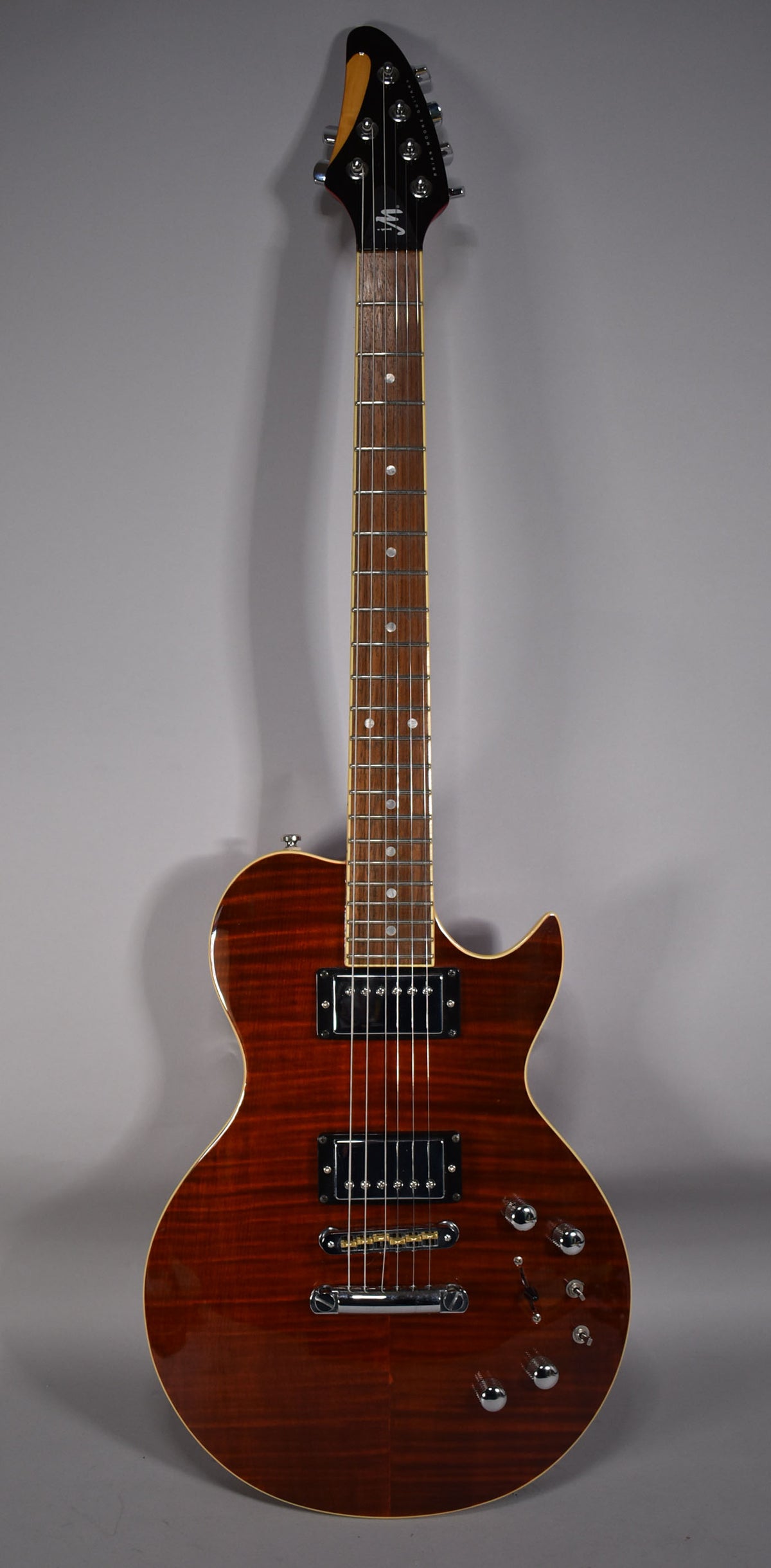 Full front view of a dark cinnamon burst electric guitar with a flamed maple top, two humbuckers, and chrome hardware.