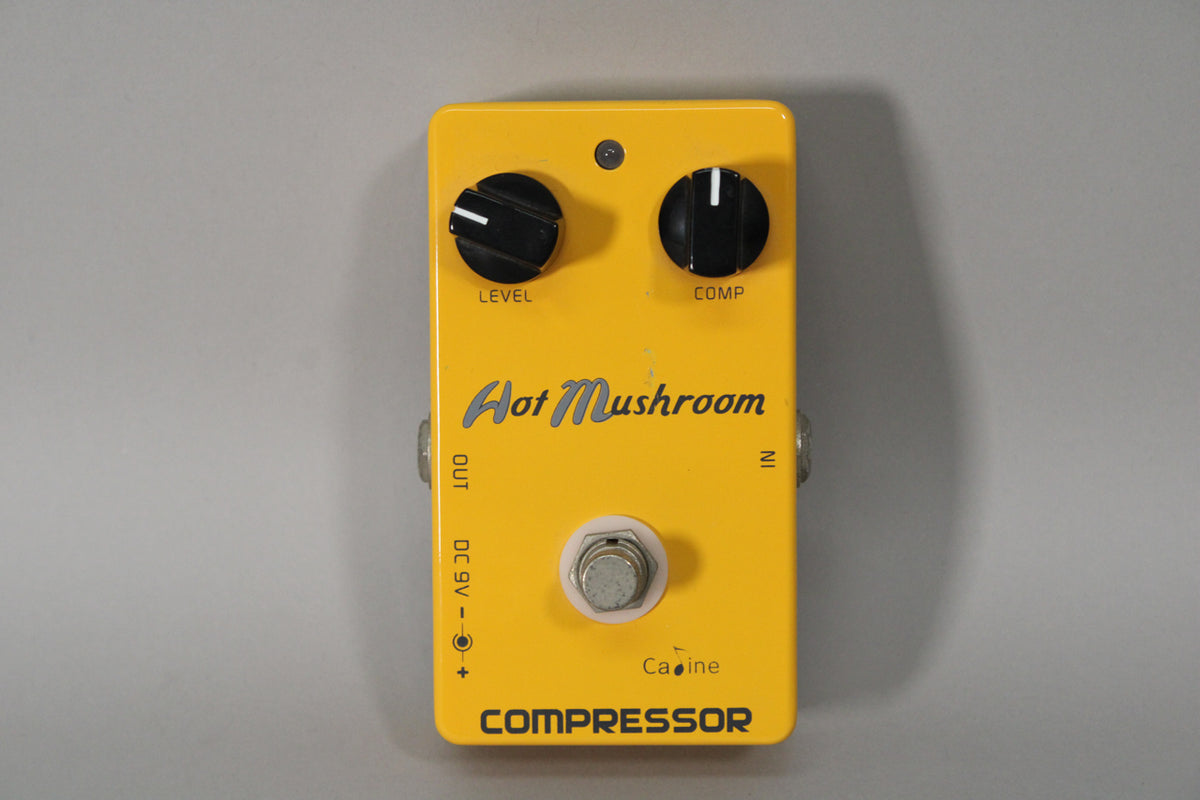 A bright yellow guitar pedal, viewed from above, with two black control knobs, a silver footswitch, and a small LED.