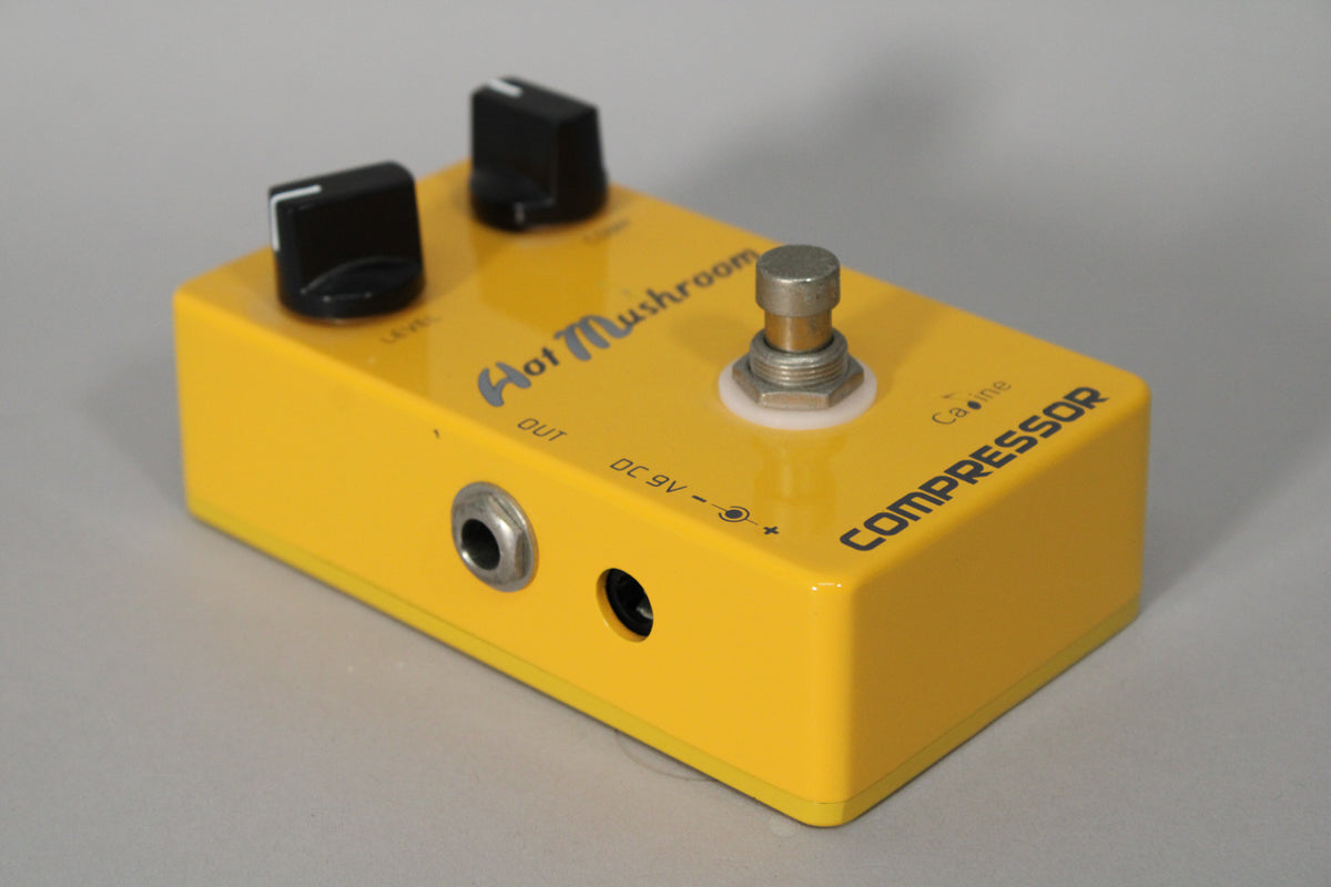 A yellow Caline Hot Mushroom Compressor pedal with two black knobs, a footswitch, and "OUT" and "DC 9V" ports.