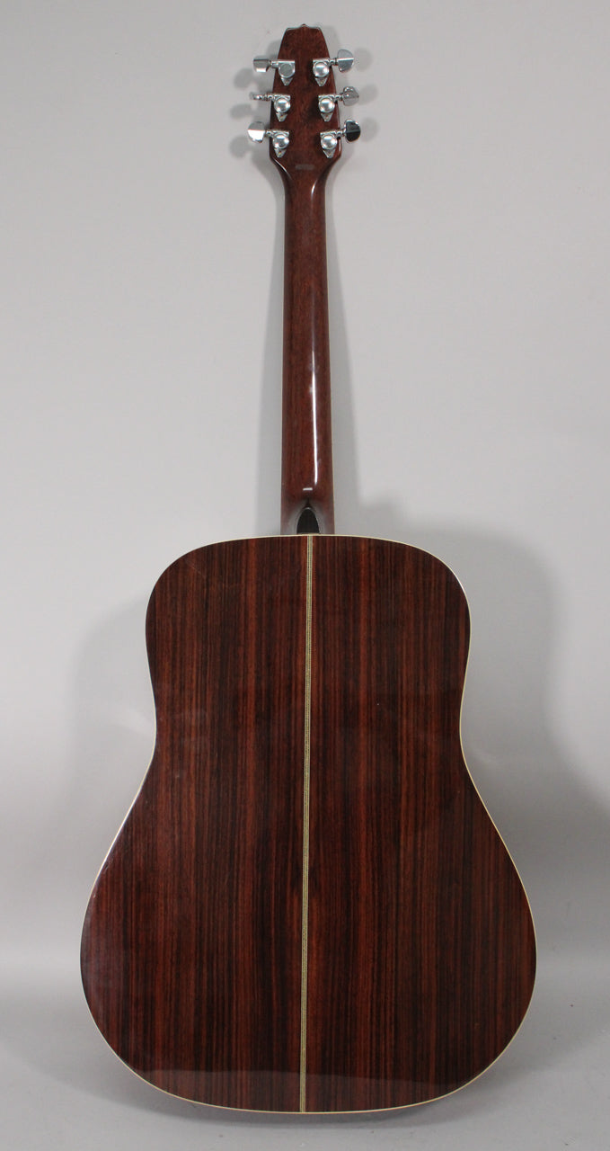 The guitar's back and neck are dark brown with a glossy finish, featuring a light center strip and chrome tuners.