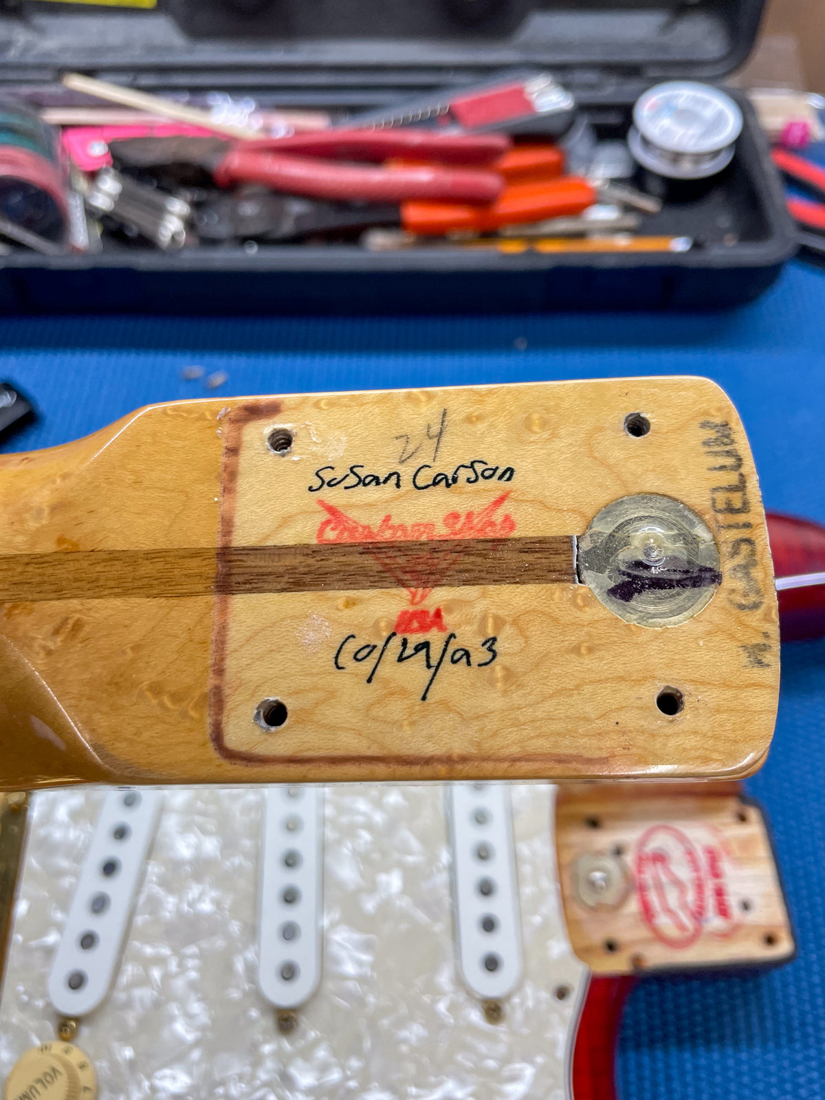 The guitar's neck heel, with a dark wood stripe, shows handwritten "Susan Carson" and "10/29/93" on light wood.