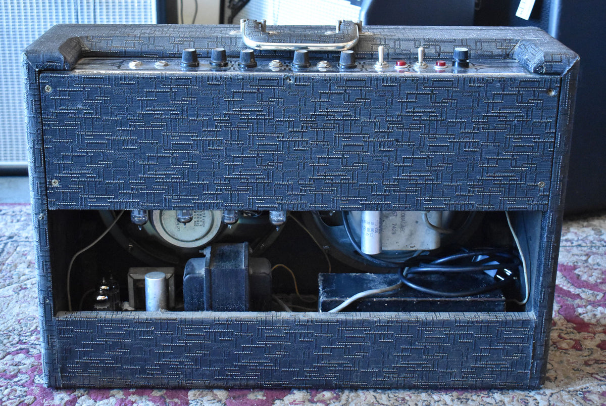 Rear view of the dark blue patterned amplifier, showing the open back with visible tubes, speakers, and internal wiring.