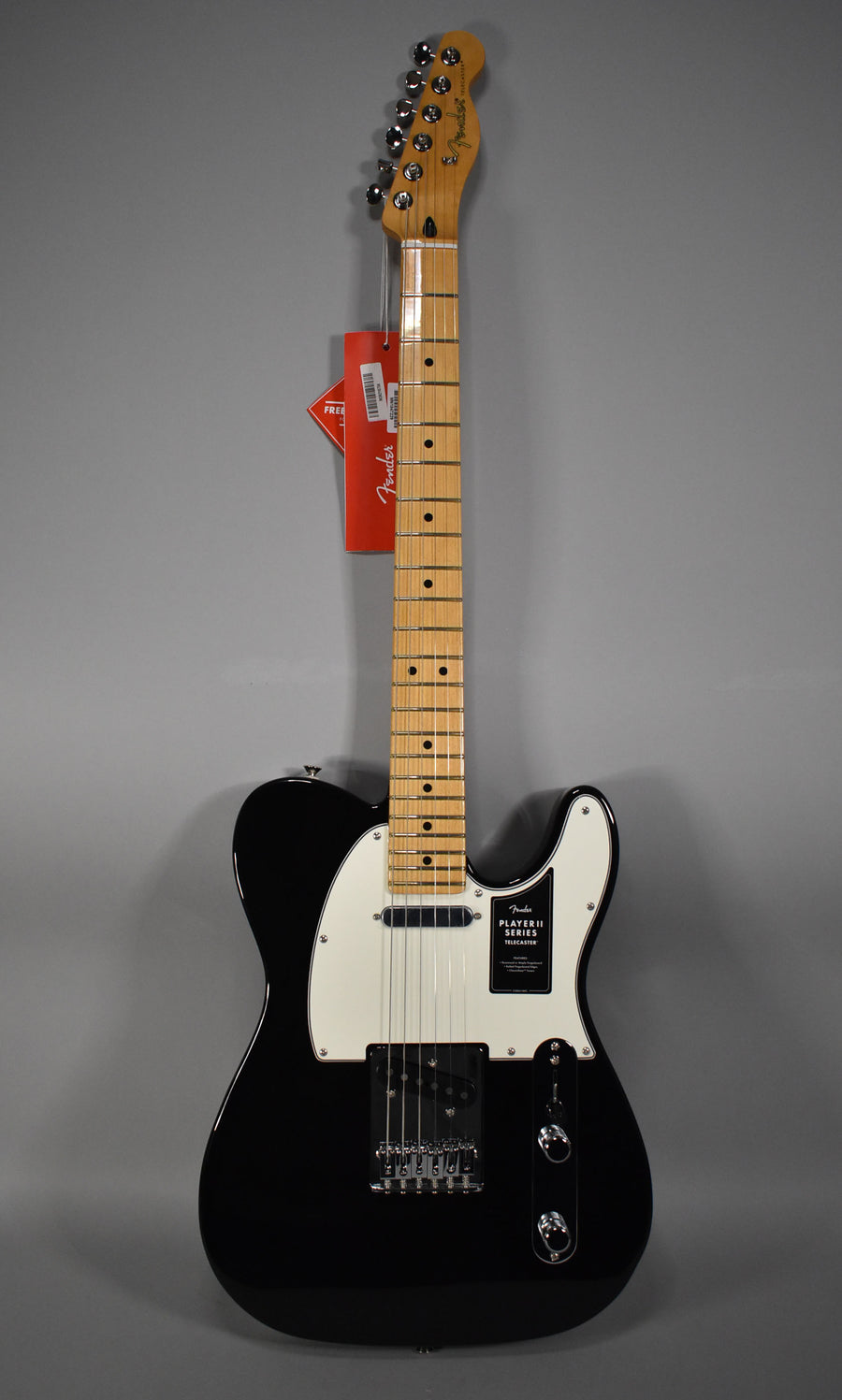 Full-length view of a glossy black Telecaster with a white pickguard, maple neck, and chrome hardware, including two control knobs.