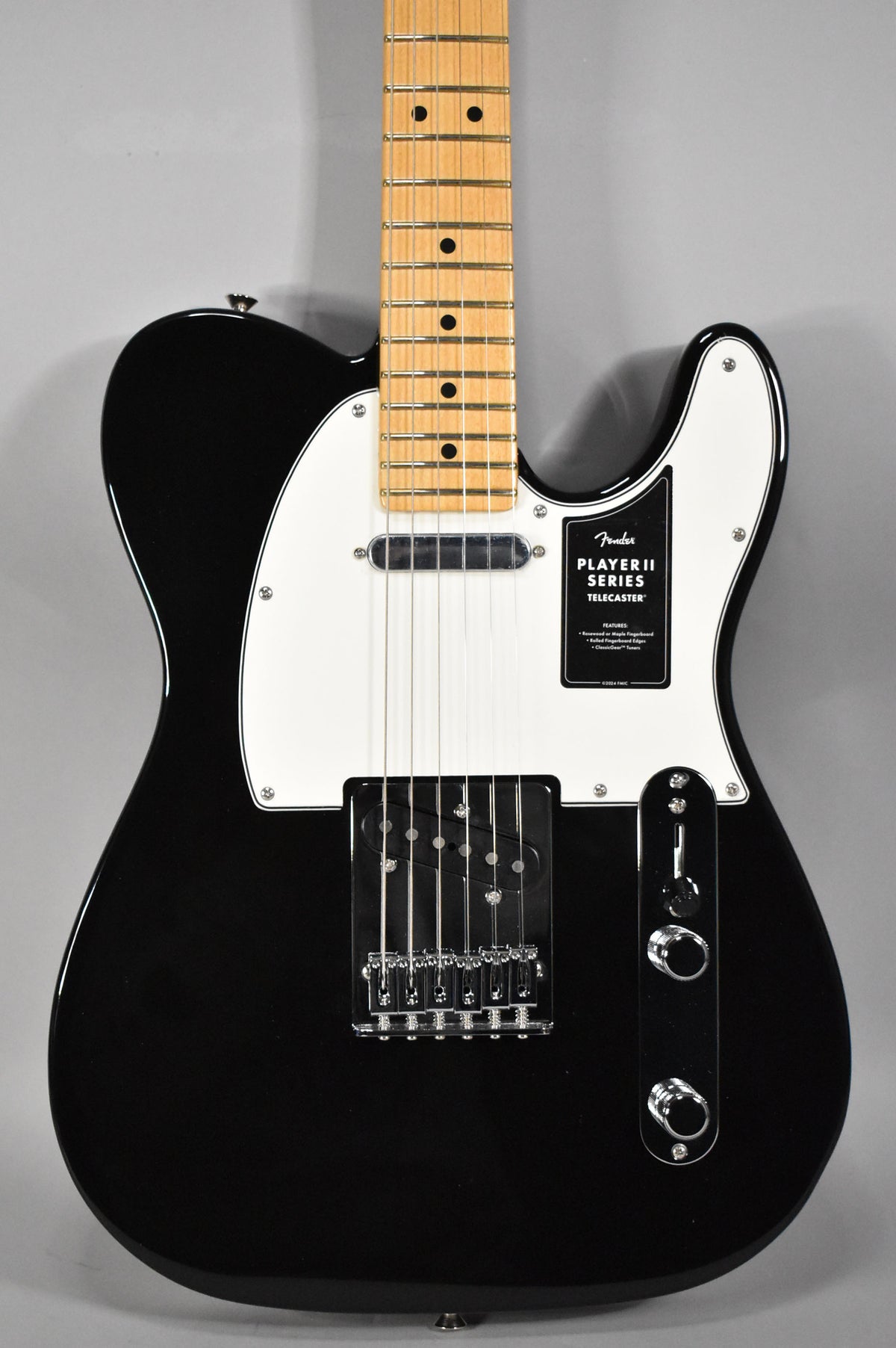 A black Telecaster with a white pickguard, maple fretboard, chrome hardware, and a black humbucker bridge pickup.