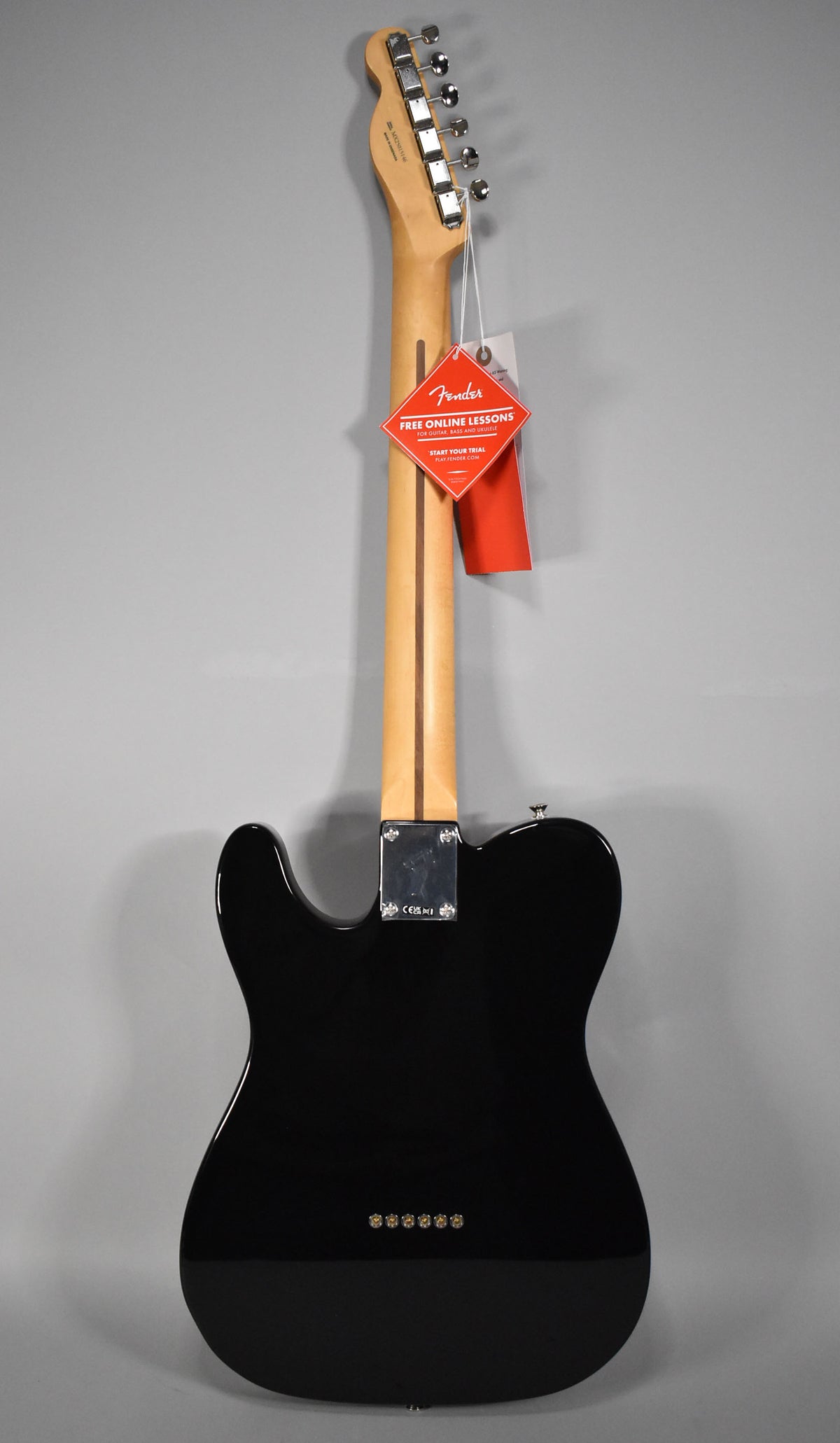 Full rear view of a black Telecaster with a glossy finish, showing the maple neck, chrome tuners, and six string-through-body ferrules.