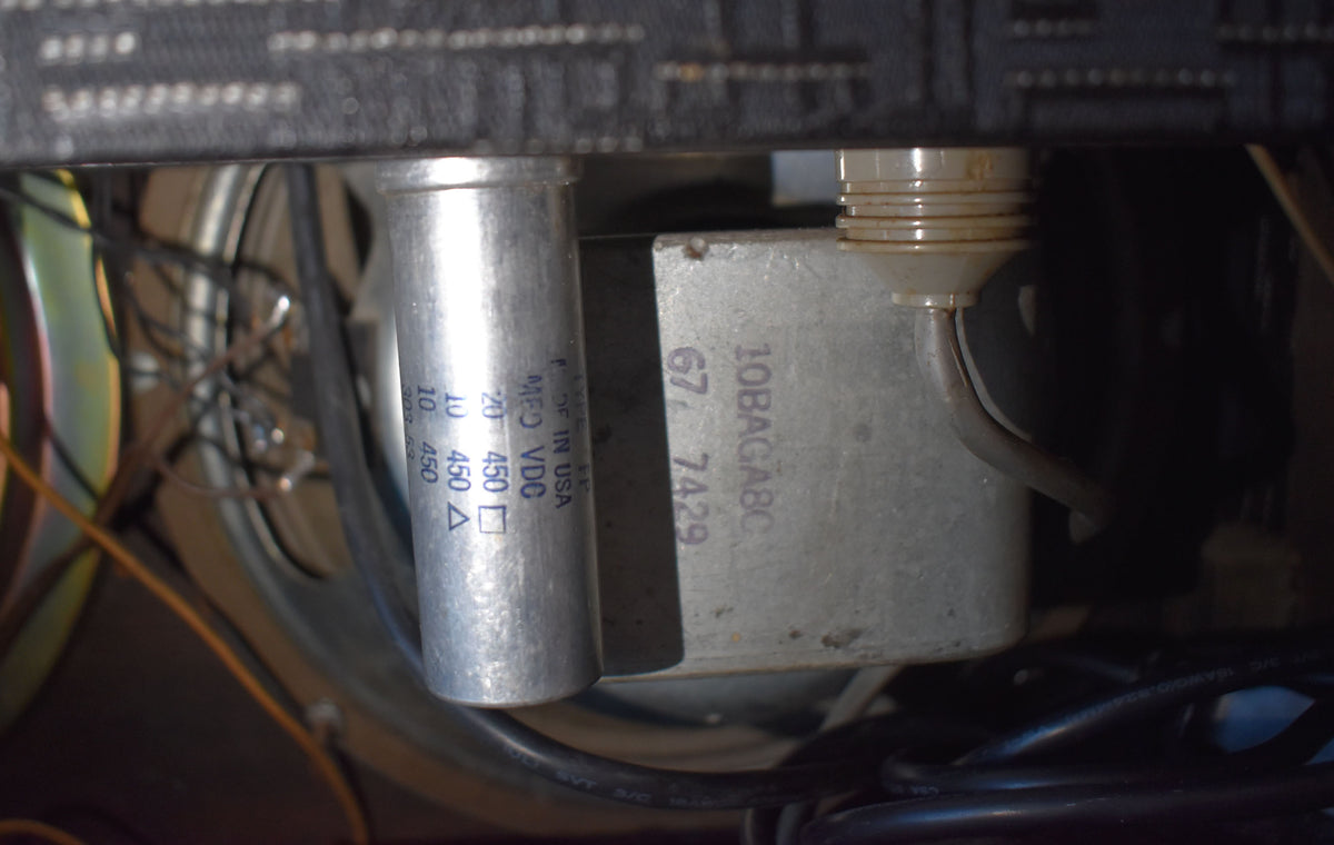 Close-up of the amplifier's internal components, showing a large silver capacitor and a metal transformer with visible wiring.