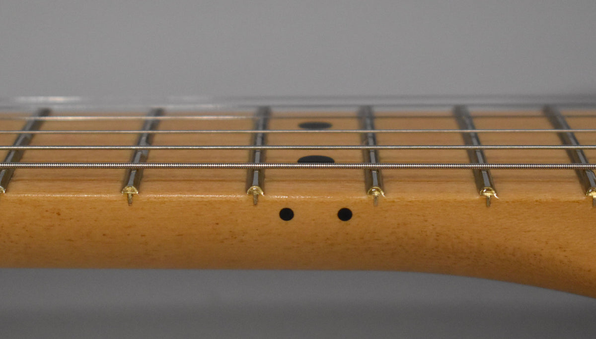 Close-up of the Telecaster's maple neck and fretboard, showing frets 1-7, black dot inlays, and two black side dots.