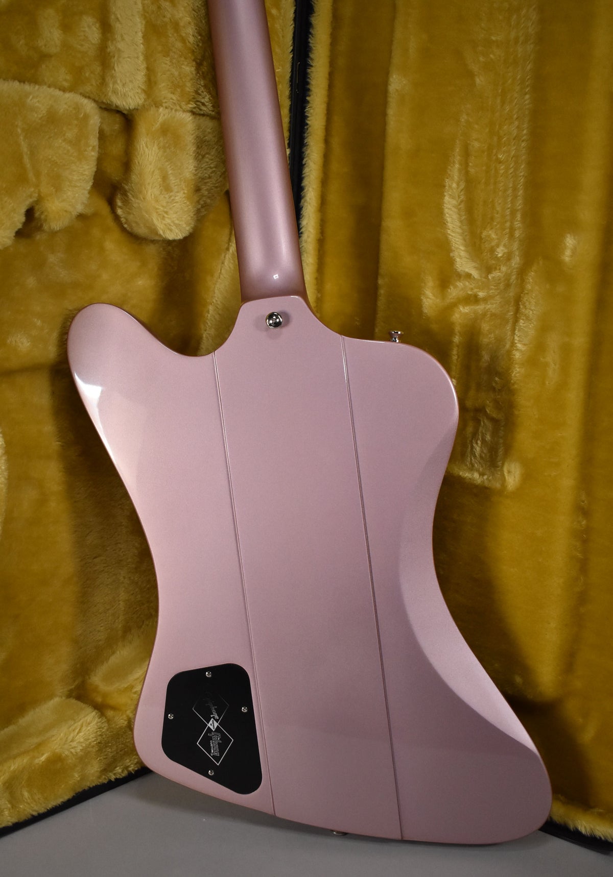 The back of a glossy heather poly Firebird guitar, showing the neck joint, strap button, and control cavity cover.