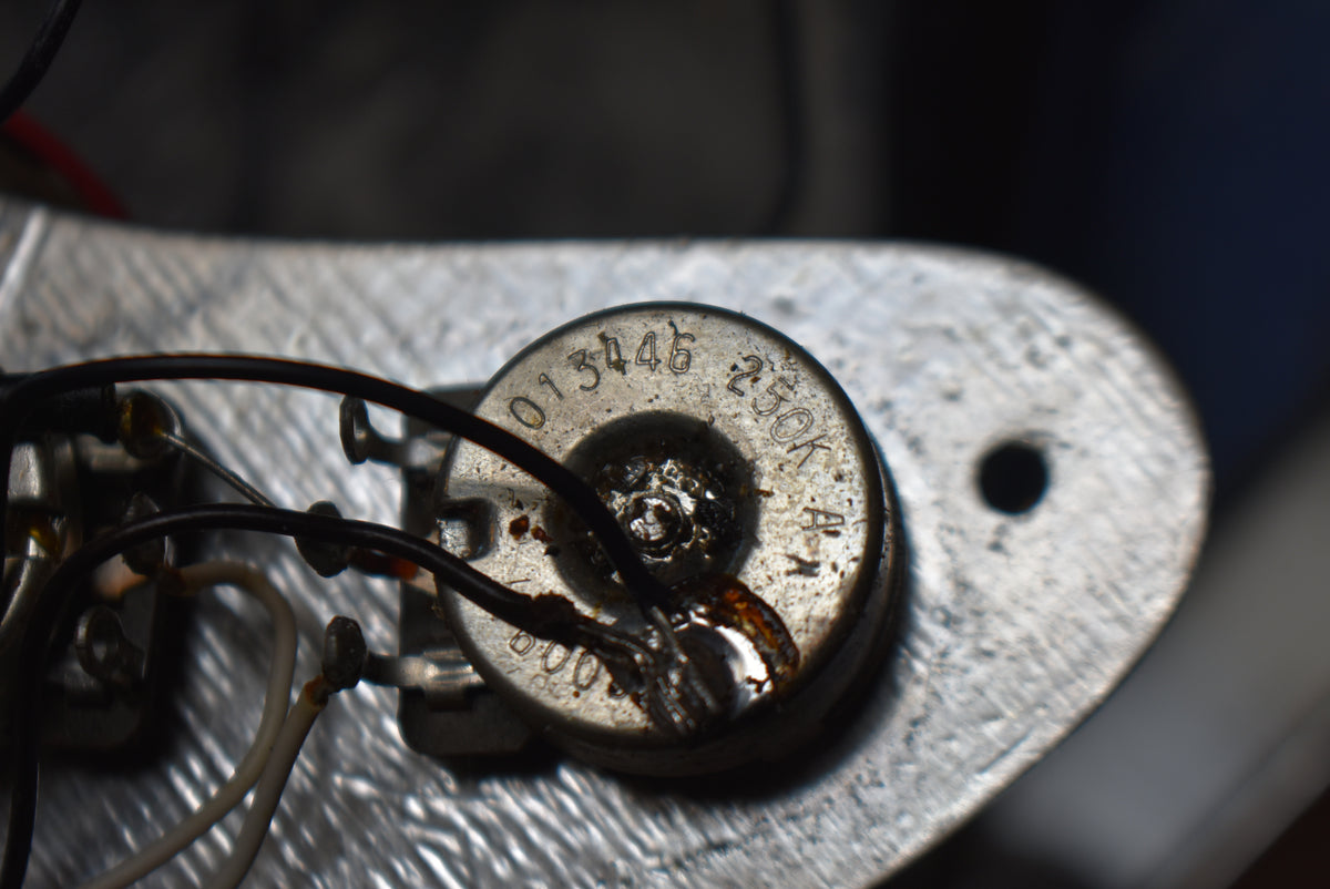 Close-up of a potentiometer with "013446 250K A" stamped on its metal casing, showing solder joints and wiring.