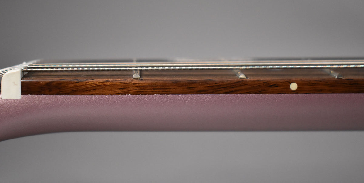 Close-up of the heather poly neck and dark fretboard with a white nut, frets, strings, and a single side dot.