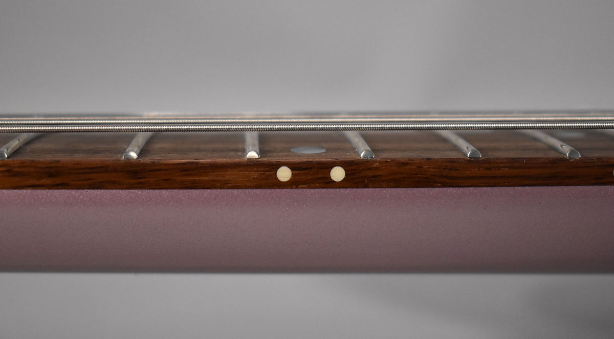 Close-up of the guitar's dark fretboard and two light-colored side dot markers, with the heather poly neck visible below.