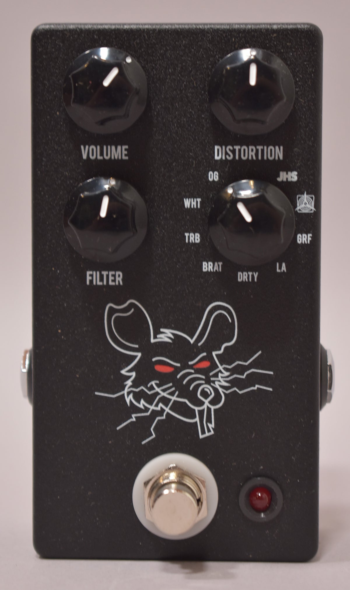 The black textured pedal features four black knobs, a silver footswitch, a red LED, and a white rat graphic with red eyes.