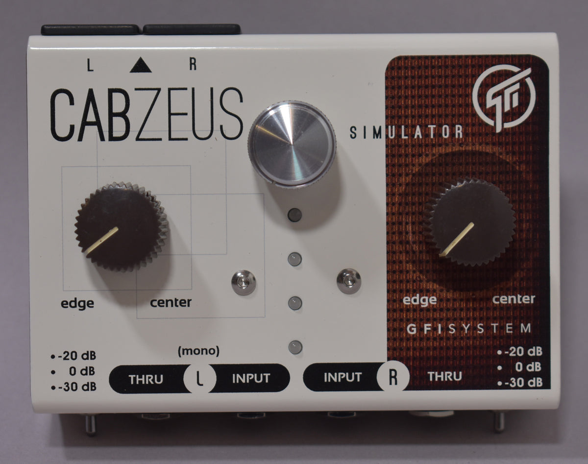 Top-down view of a white pedal with a large silver knob, two smaller black knobs, and a brown textured panel on the right.