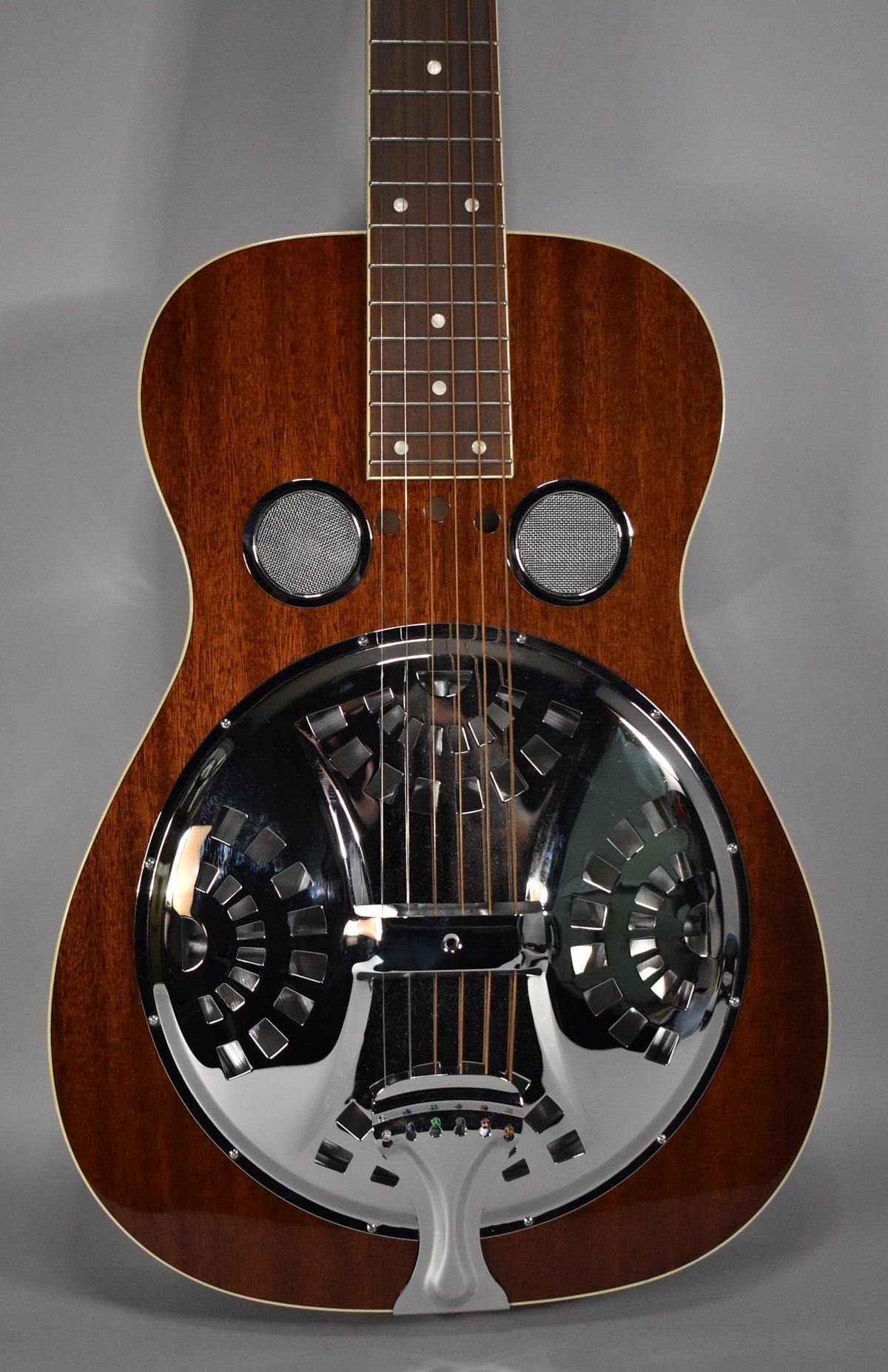 The resonator guitar's body is framed from the neck joint down, showing its natural gloss finish and chrome resonator cone.