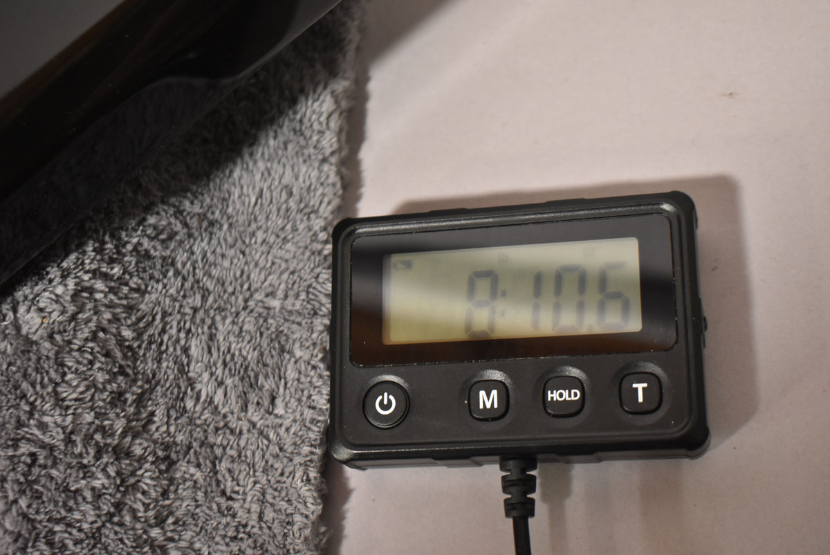 The black Warlock's upper horn rests on a grey fuzzy surface next to a digital scale display reading 8 lb 10.6 oz.