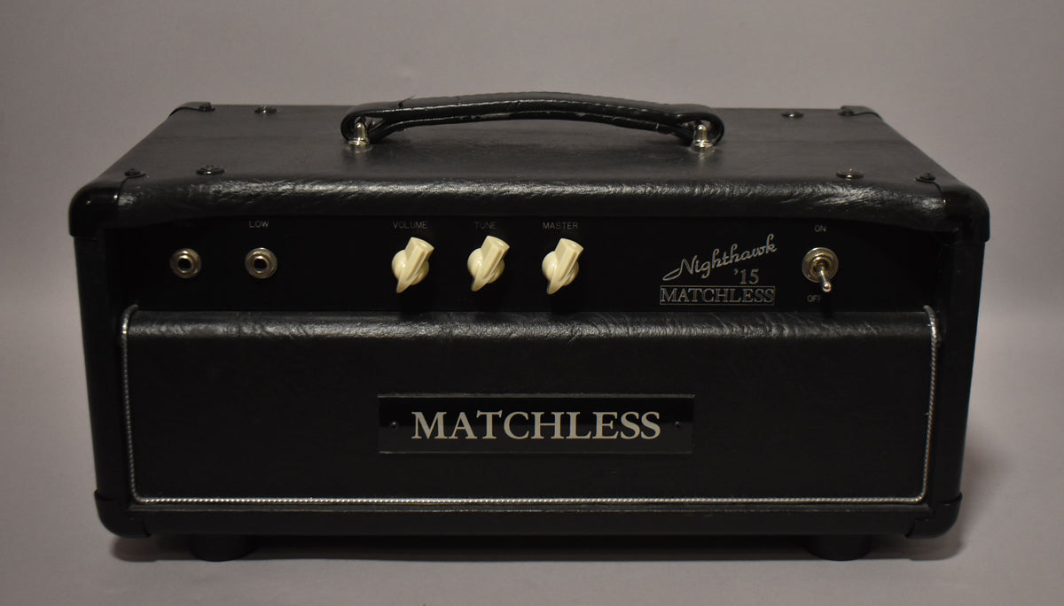 Front view of a black tube amplifier head with a textured finish, a leather handle, two input jacks, three cream chicken-head knobs, and a toggle switch.