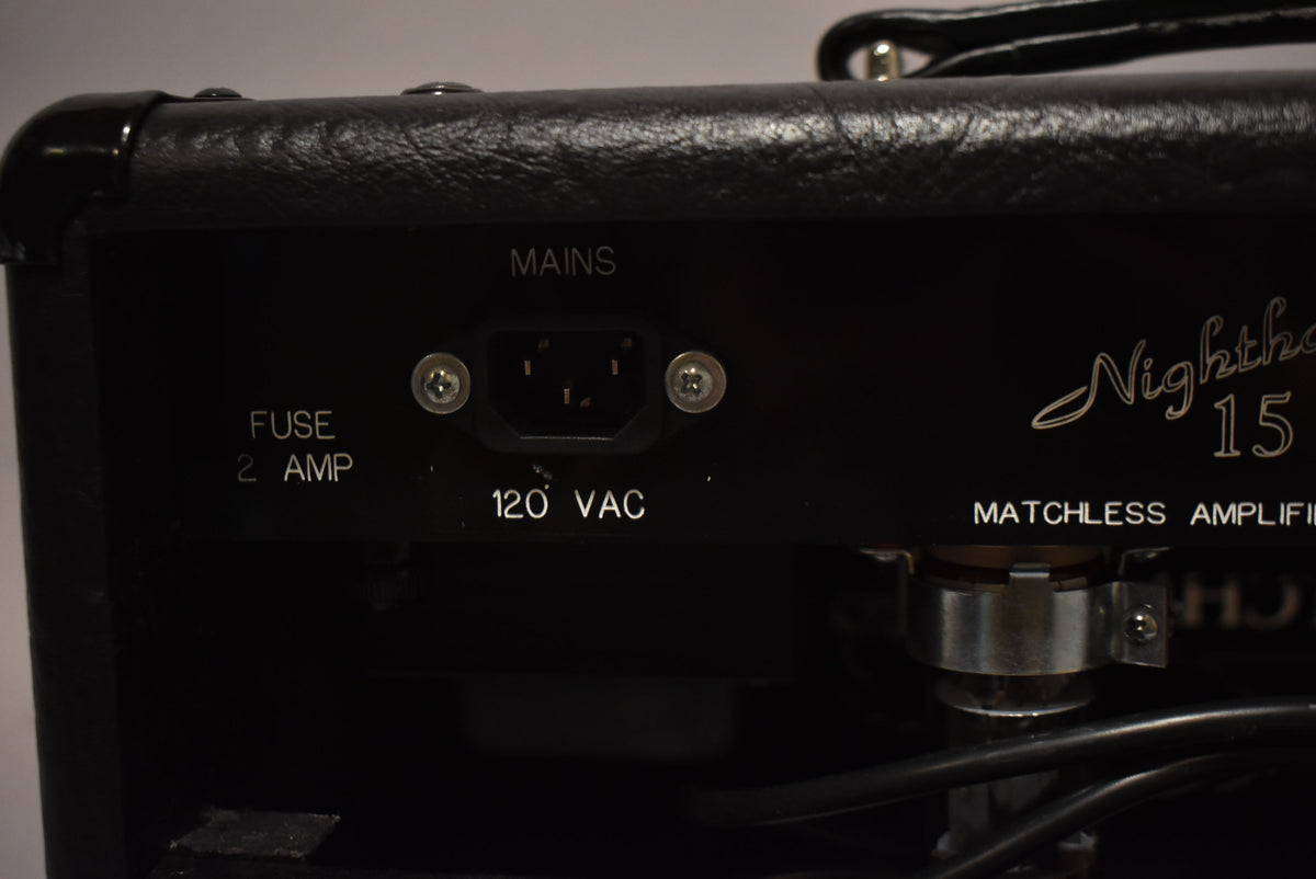 Close-up of the black amplifier's rear panel, showing the IEC mains input, fuse holder, and "120 VAC" power rating.