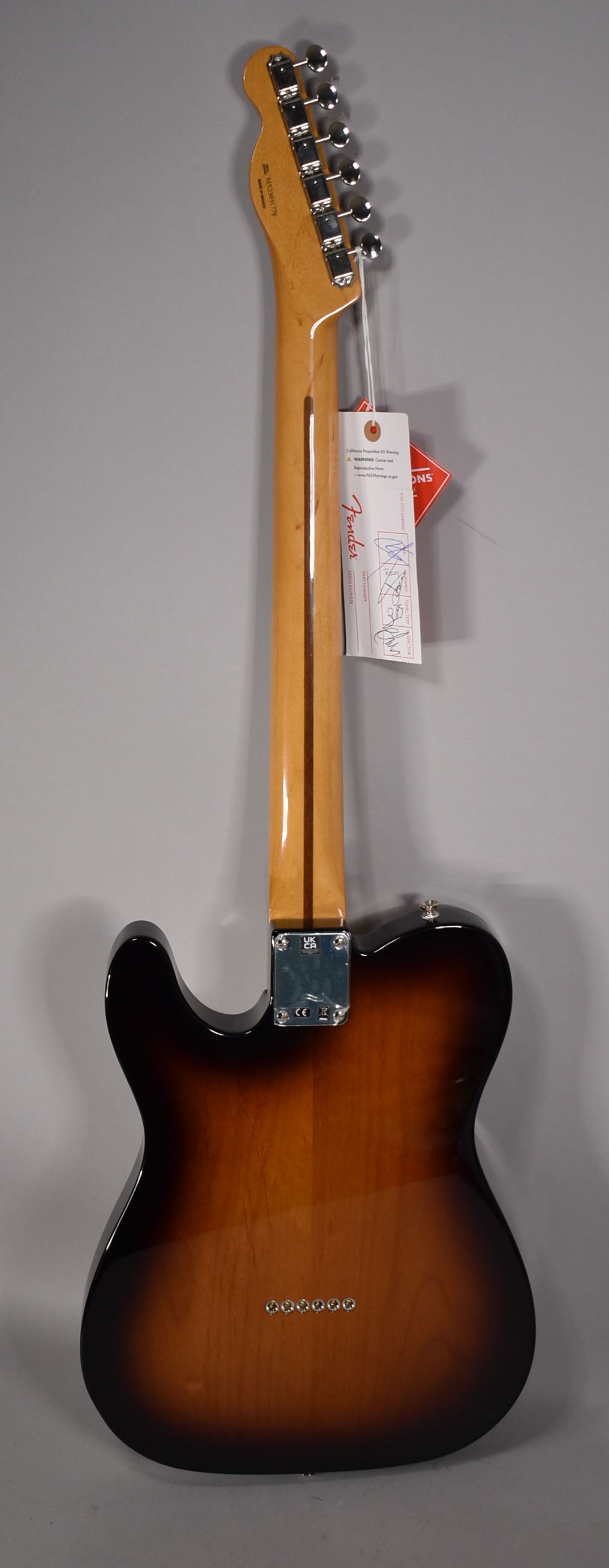 The guitar's back, neck, and headstock are visible, showing a glossy 2-color sunburst finish and chrome hardware.