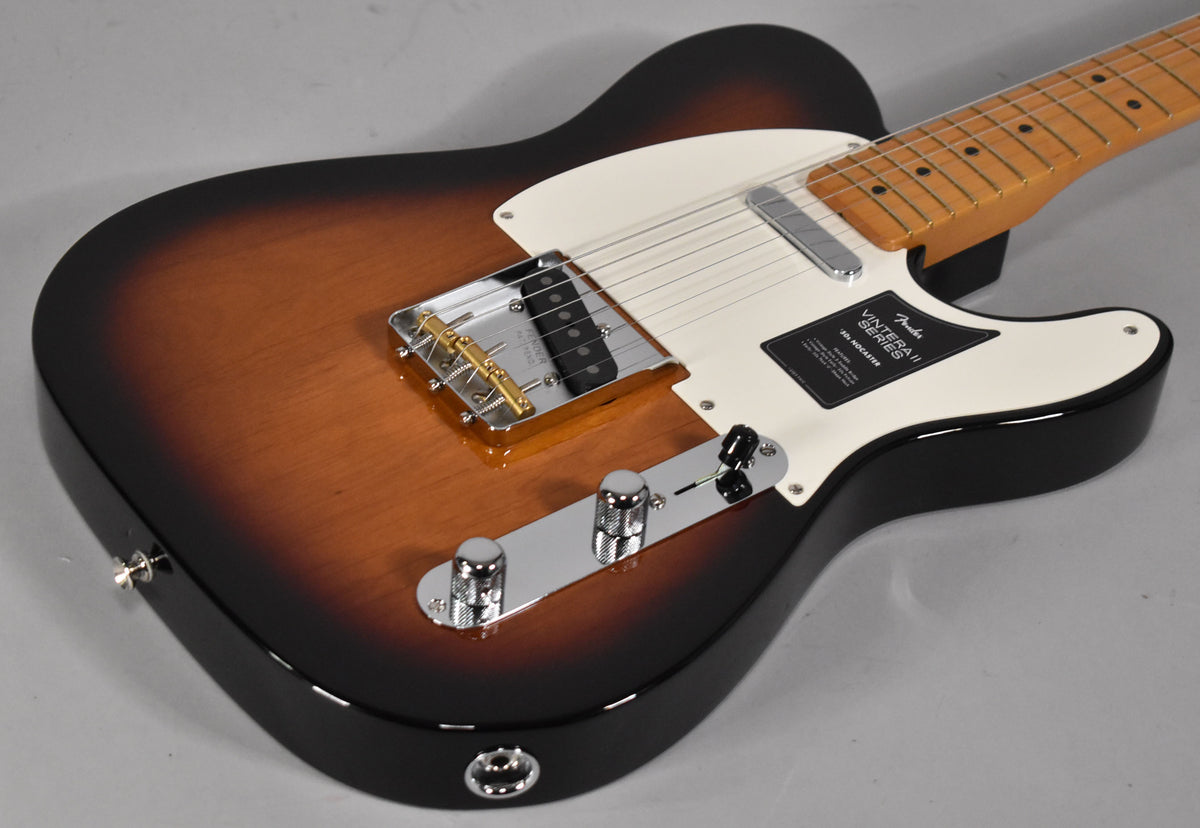 The guitar's body, in 2-color sunburst, is angled from the lower right, showing its white pickguard, chrome bridge, and control plate.
