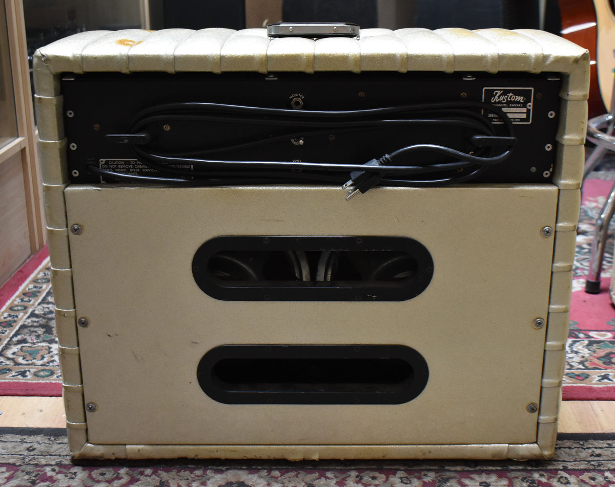 Rear view of the Kustom combo amp, showing its off-white sparkle tuck-and-roll finish, two oval speaker ports, and power cable.