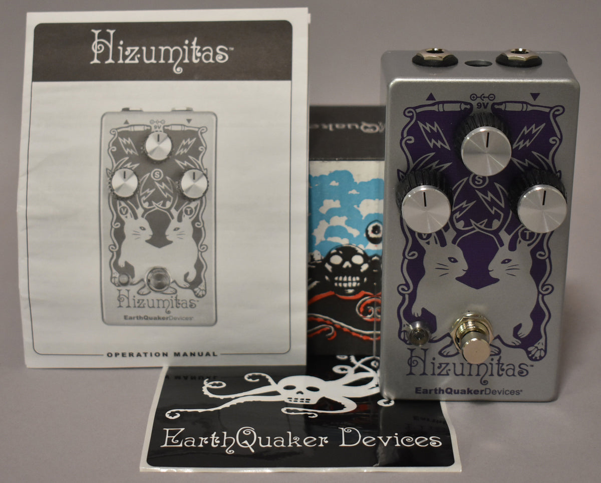 A silver guitar pedal with purple cat-like creatures and lightning bolts, three silver knobs, and a footswitch.
