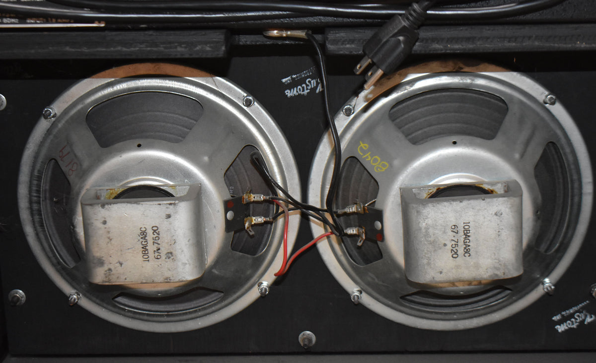 Rear view of the amplifier's two silver-framed speakers, showing their black cones, exposed wiring, and magnet structures.