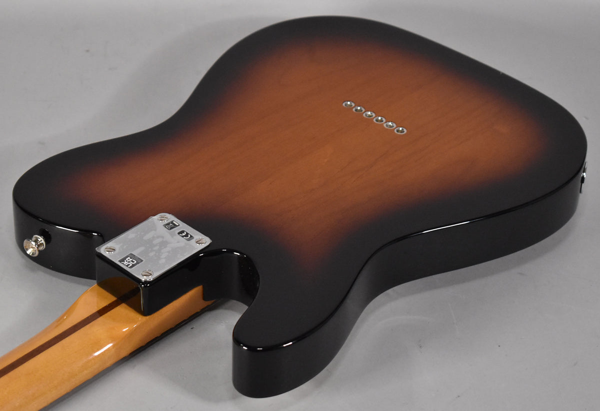 The guitar's glossy 2-Color Sunburst back, showing the neck plate, six string ferrules, and a strap button.