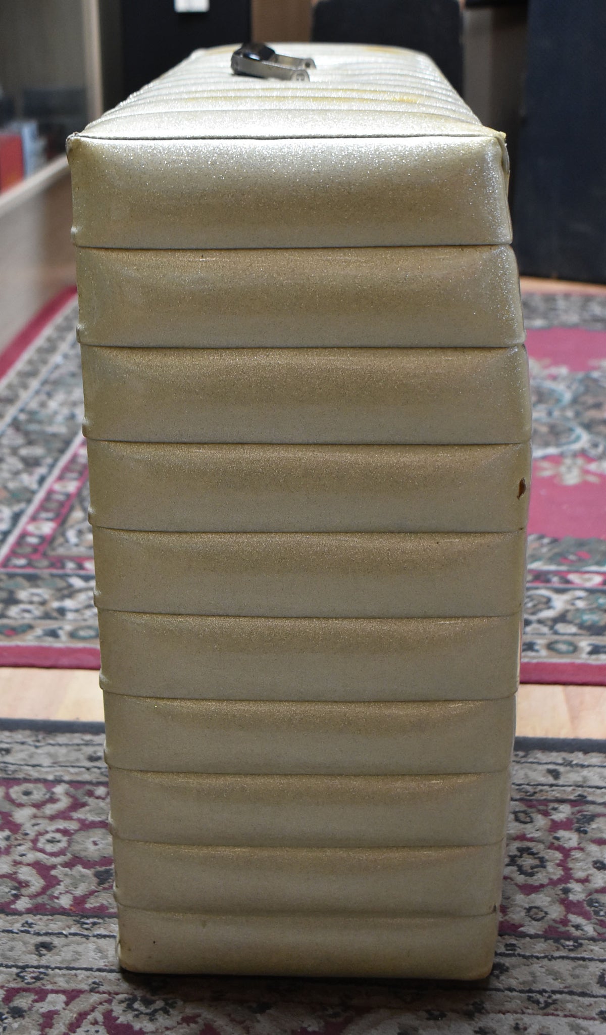 The amp's right side is shown, covered in gold sparkle tuck-and-roll vinyl with a small tear near the top.