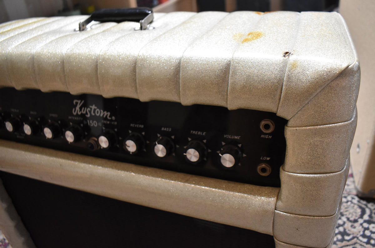 Close-up of the amp's top and front panel, showing the silver sparkle tuck-and-roll covering with some stains and a small tear, and black control panel with silver knobs.