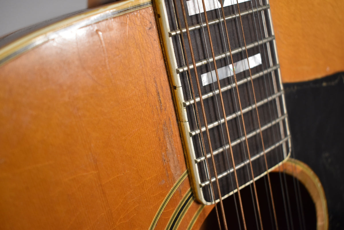 Close-up of the natural blonde body and dark fretboard with rectangular inlays, showing wear and checking on the finish.