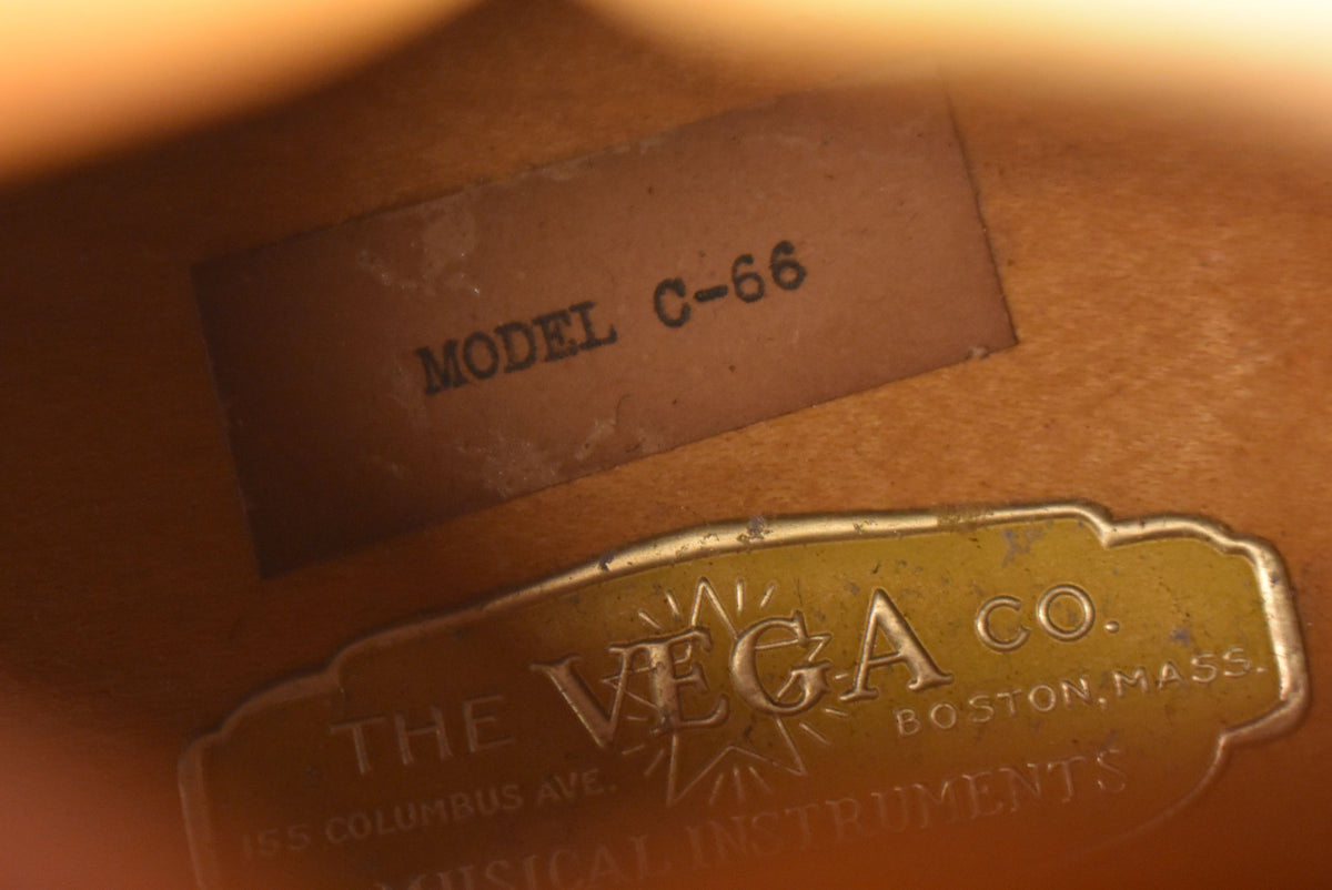 Close-up of the guitar's interior, showing a "MODEL C-66" paper label and a tarnished brass "THE VEGA CO." plate.