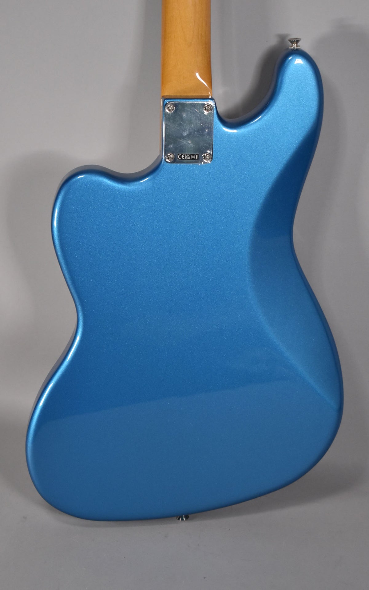 The back of a Lake Placid Blue Bass VI, showing the metallic finish, chrome neck plate, and a light-colored maple neck.