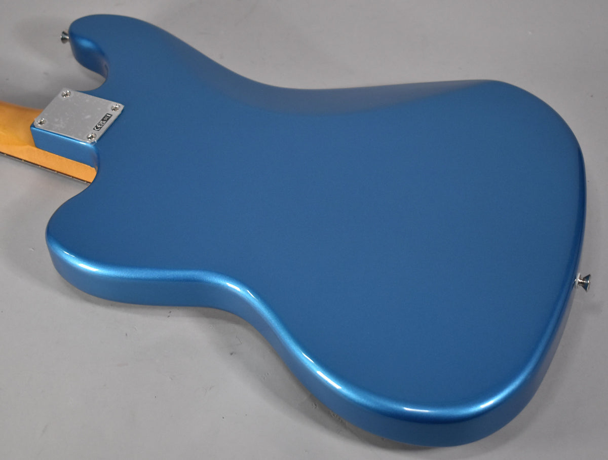 The back of a metallic Lake Placid Blue bass guitar body, with a chrome neck plate and strap button visible.