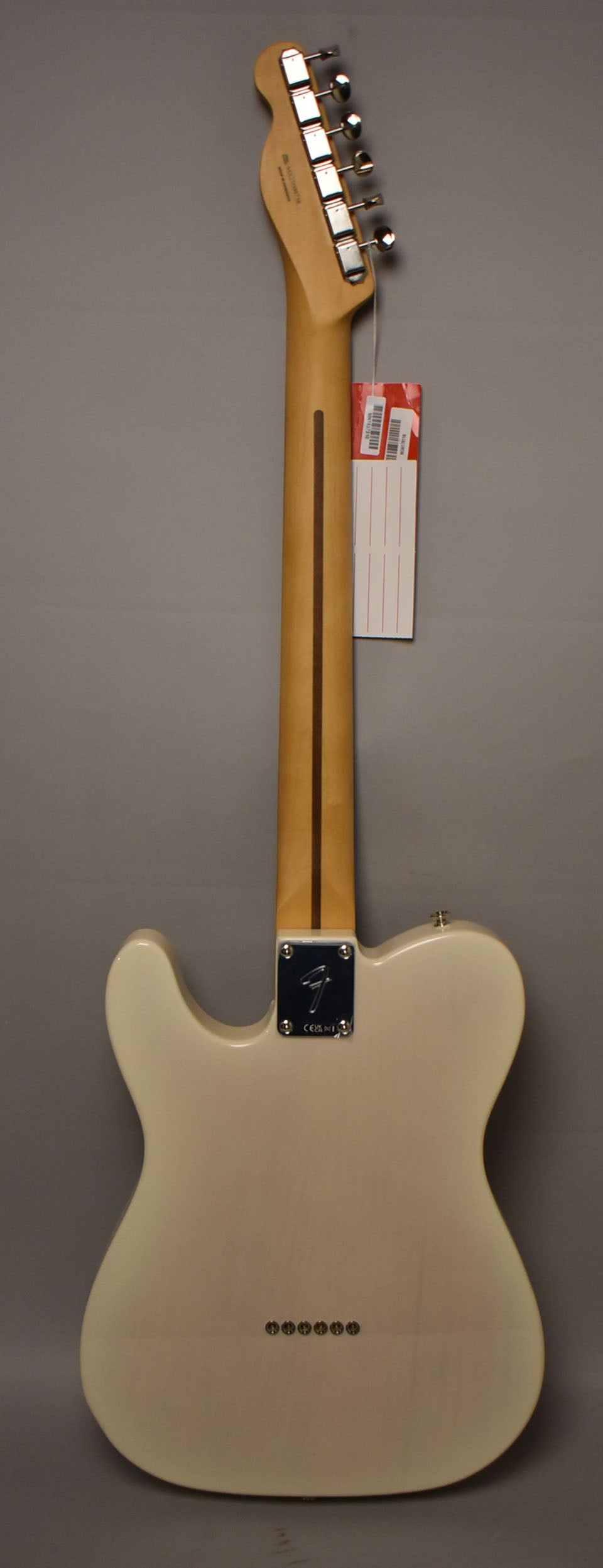 The back of a white blonde Telecaster, showing the neck, headstock with six tuners, and string-through-body ferrules.