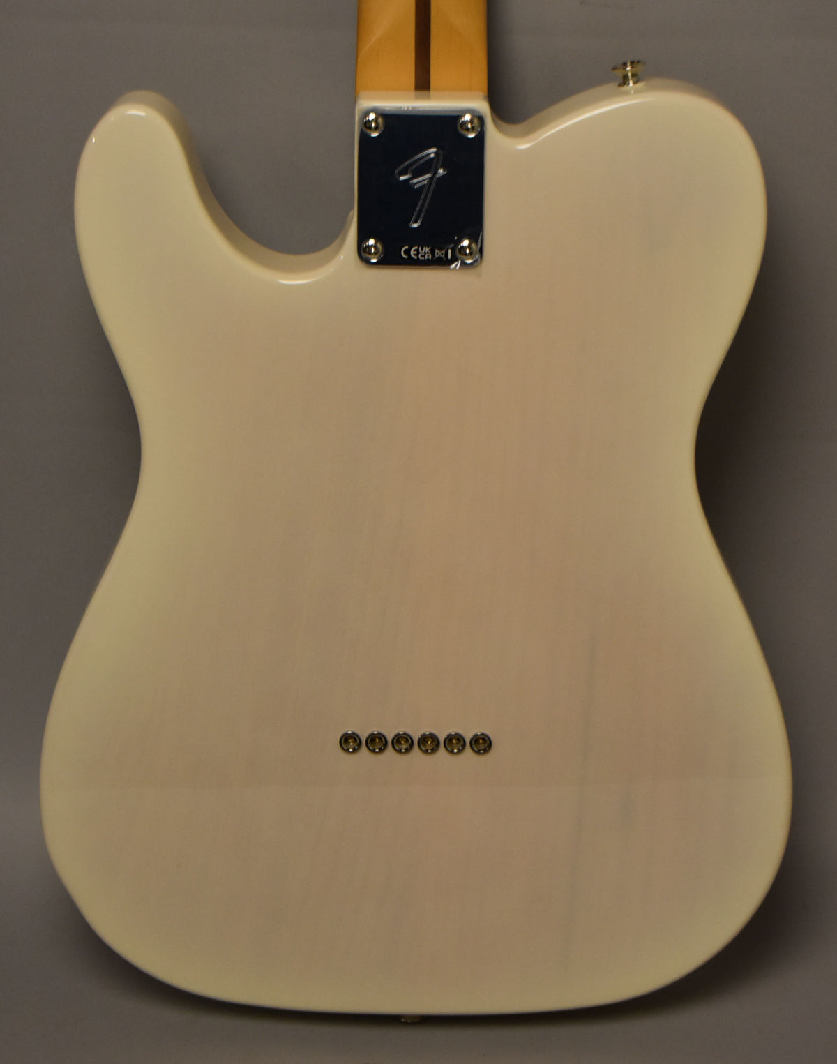 The back of a White Blonde Telecaster, showing the neck plate, string ferrules, and a strap button.