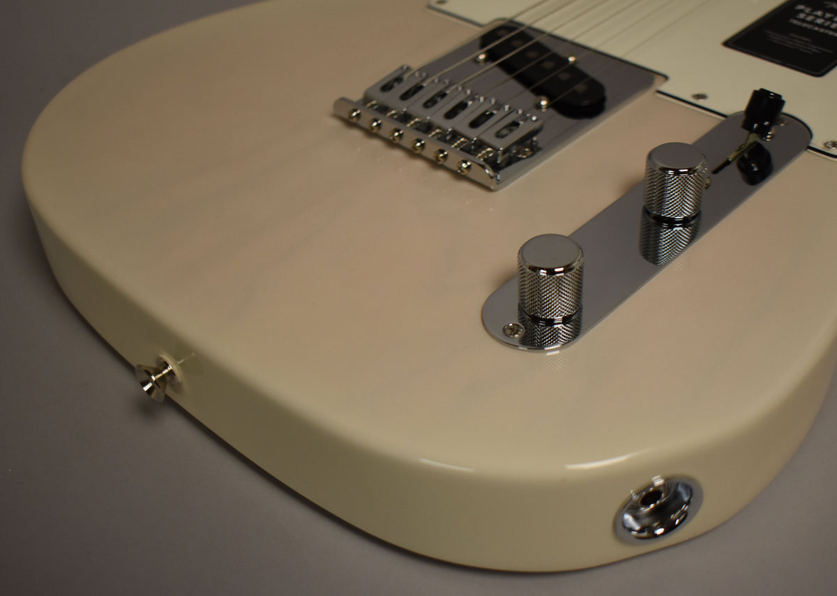 Close-up of the Telecaster's White Blonde body, showing the chrome bridge, control plate with two knurled knobs, and output jack.