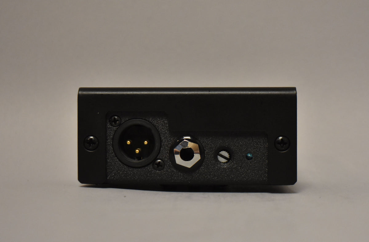 The black pedal's rear panel shows an XLR input, a 1/4-inch jack, a small screw, and a blue indicator light.