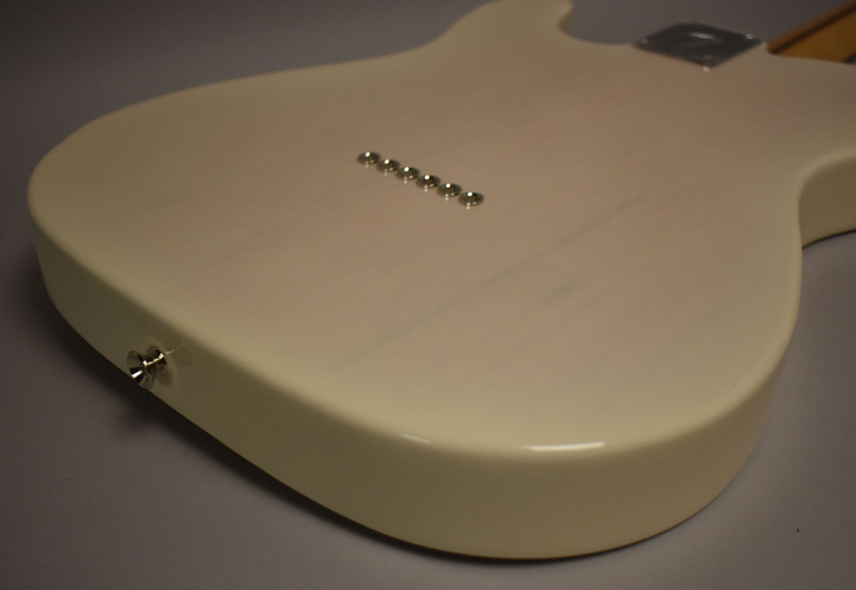 The back of a White Blonde Telecaster body, showing six string-through-body ferrules and a strap button.