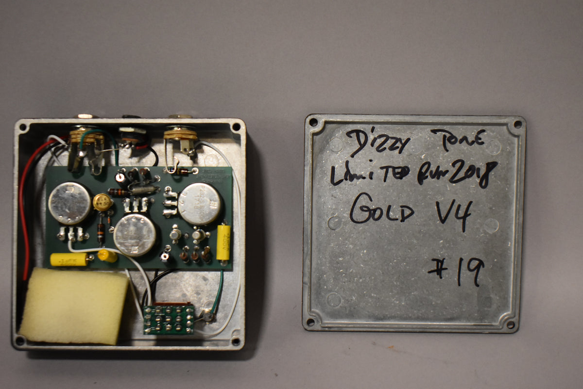 An open effects pedal with internal circuitry and a separate cover with "Dizzy Tone Limited Run 2018 Gold V4 #19" handwritten on it.