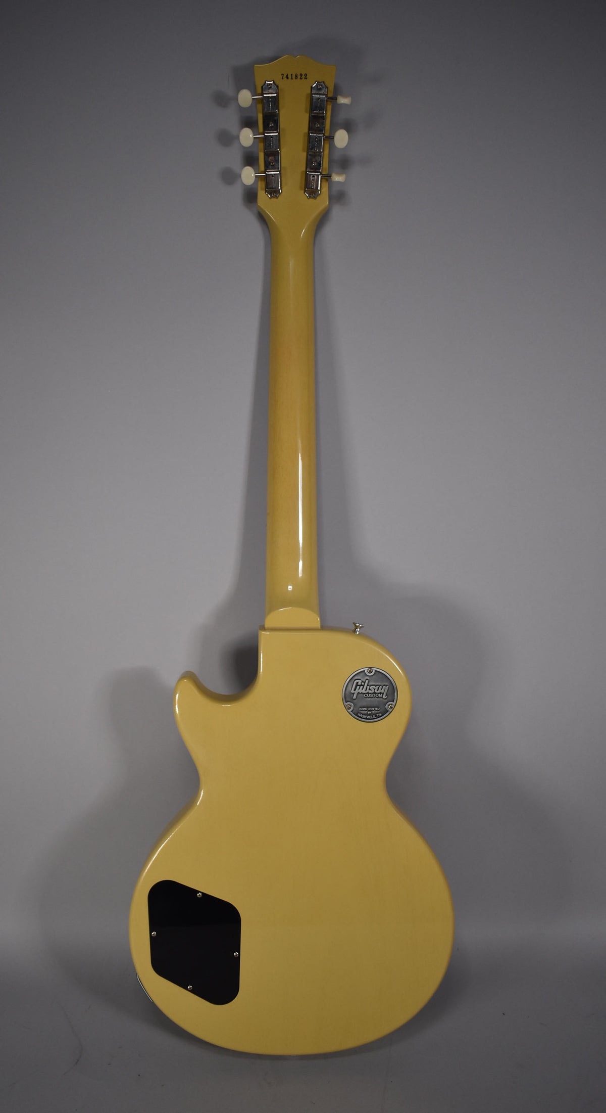 The back of a TV yellow single-cut guitar, showing the headstock with six tuners, neck, and body with a black control cavity cover.