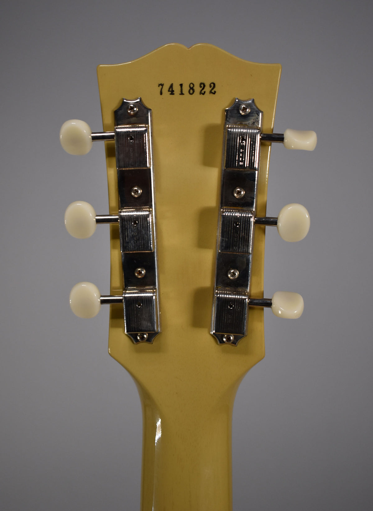 The back of a TV Yellow headstock and neck, showing six cream-buttoned tuners with chrome housings and a serial number 741822.