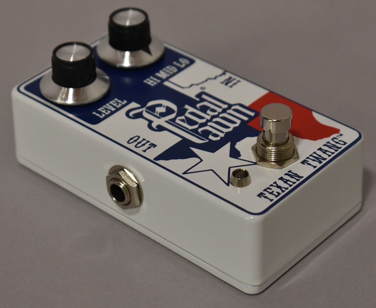 A white pedal with a blue and red Texas flag graphic, two silver-capped black knobs, a silver footswitch, and an output jack.