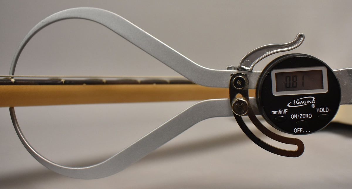 A digital caliper measures the neck thickness of the Telecaster, showing "0.81" on its display.