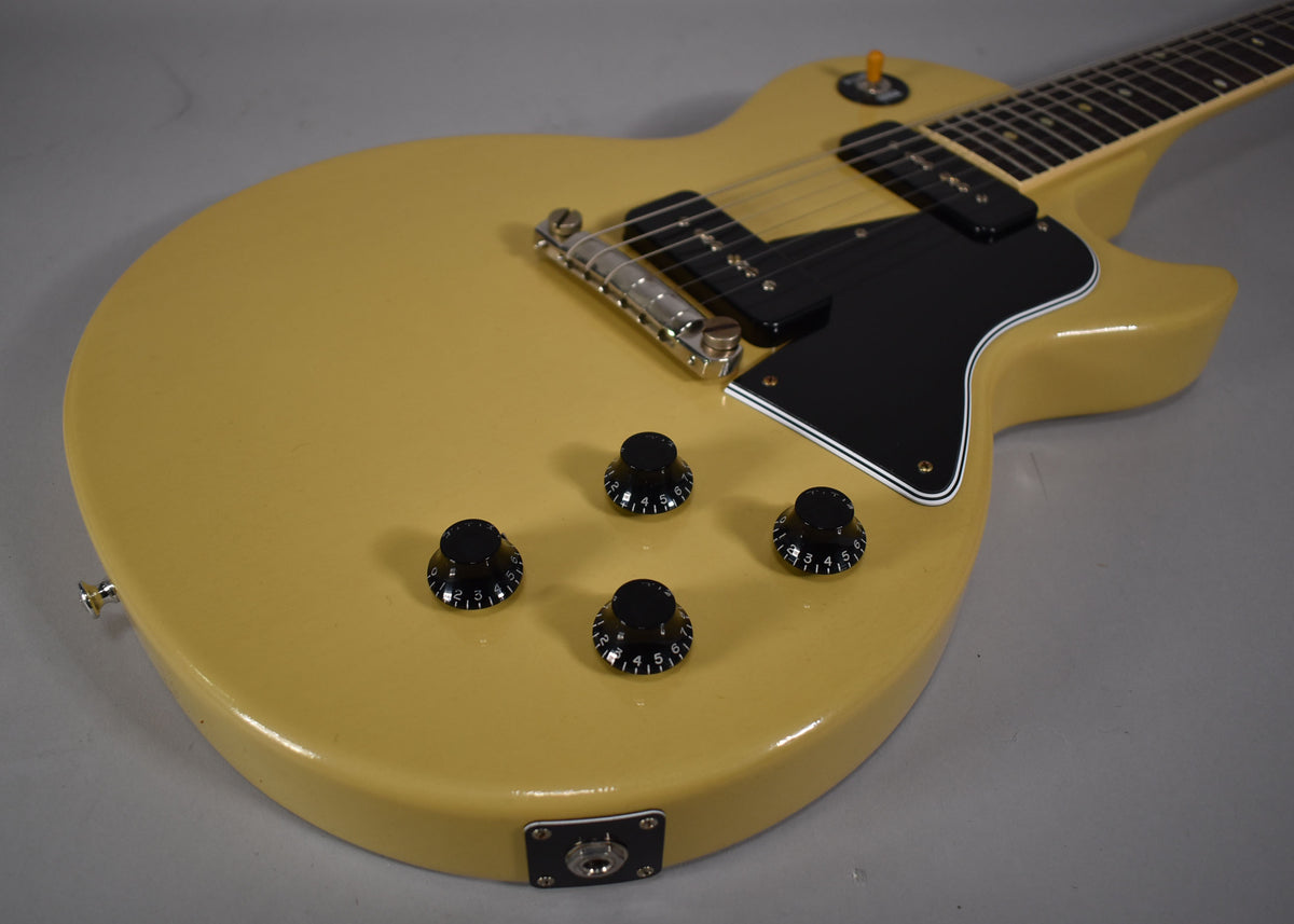 TV yellow single-cut guitar, angled from the lower bout, showing four black numbered knobs, output jack, and black pickguard.