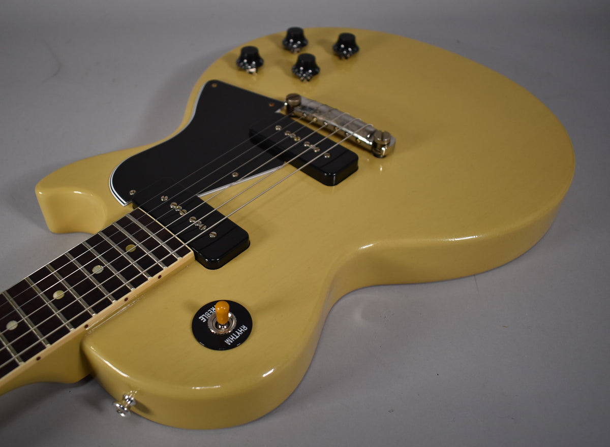 The TV yellow single-cut guitar body is angled from the neck, showing two black P90 pickups, a black pickguard, and four black control knobs.