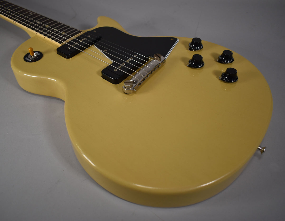 The TV yellow single-cut guitar body is angled, showing two black P90 pickups, a black pickguard, and four black control knobs.